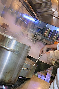 Šéfkuchár varenie v reštaurácii kuchyňa s dym von z panvice.