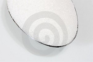 Makro snímek bílý cukr v lžící (zaměření na přední části cukru)