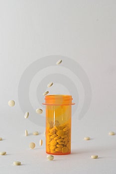 Liek fľašu na stôl s bielym tablety, ktoré patria do a okolo neho fľaša je umiestnený v strede rámu s tabletky mrazené v stop motion patriace do a okolo fľaše.