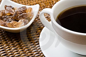 Šálek černé kávy s rock cukr.