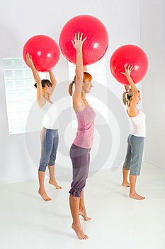 Skupina žien, ktoré robia fitness cvičenie s veľkou loptou.