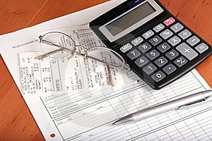 Concetto finanziario con la calcolatrice, il vetro, la penna e bill.