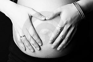 Le mani della donna incinta su pancia.