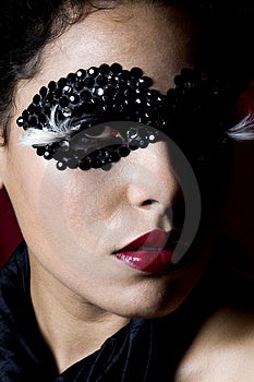 Attraente giovane donna Ispanica indossa un nero gemma maschera.