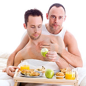 Šťastný homo pár a jejich snídani na podnos do postele.