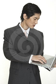 Ázijské podnikateľ udržiava aktuálne pomocou svojho notebooku.