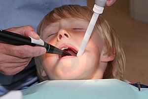 Joven chico sobre el el dentista, mirar su boca varios herramientas.